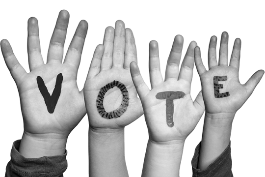 Photo of four hands with the word VOTE, one letter on each hand